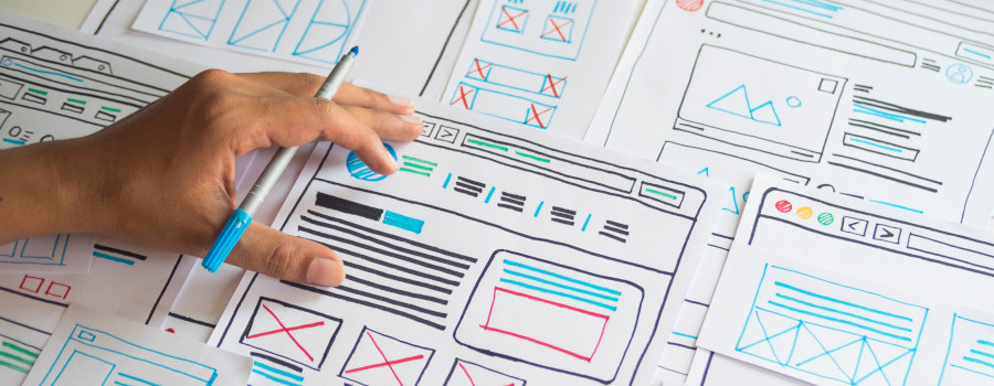A designer creating a website out of paper mockups